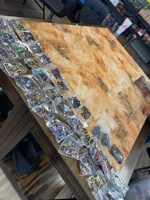 A terrain-filled tabletop battlefield viewed from above